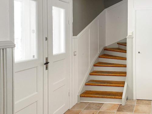 a staircase with white walls and wooden treads at 4 star holiday home in HJORTKVARN-By Traum in Haddebo