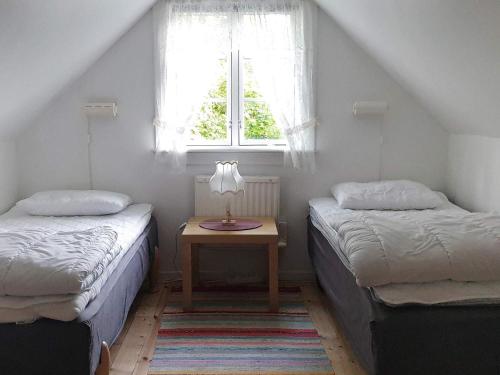 - 2 lits dans une chambre avec une table et une fenêtre dans l'établissement Holiday home Annerstad, à Skärseryd