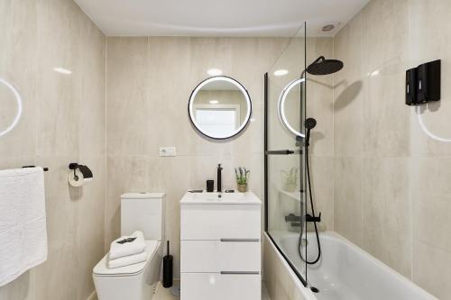 ein Badezimmer mit Toilette, Waschbecken und Spiegel in der Unterkunft Sunrise & Sunset Unique Experience Sea Views Parking Pool Mijas Costa & Fuengirola in Mijas Costa