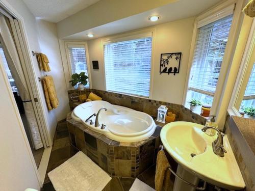 a bathroom with a tub and two sinks in it at The Blue House Bed and Breakfast in Lake Country