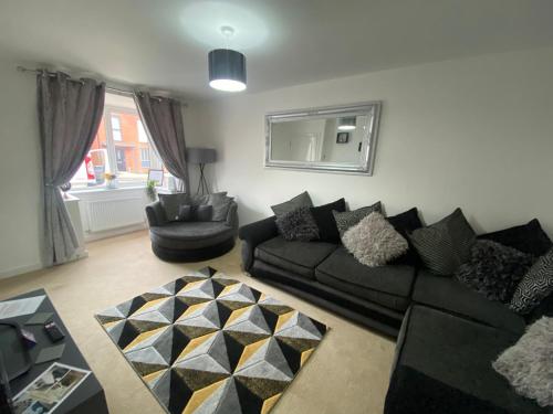 ein Wohnzimmer mit einem Sofa und einem Stuhl in der Unterkunft Kingsway House - Brand New Spacious 4 Bed Home From Home in Derby