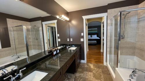 a bathroom with two sinks and a tub and a shower at Metropolitan Dream Stay with Cozy Fireplace and Hot Tub in Surrey