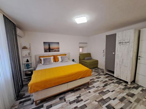 une chambre avec un grand lit et une chaise dans l'établissement Kuća za odmor Eni ****, à Šibenik