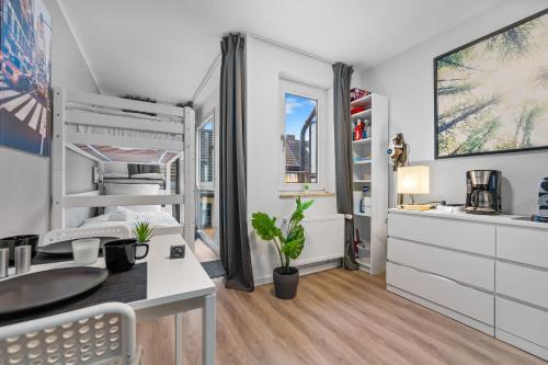 a bedroom with a bed and a desk with a sink at Messe, Monteure, Budget - Einfache komfortable 2 Personen Wohnung (22qm) mit Vollausstattung (WLAN 250 Mbit, TV 55 Zoll m. Netflix) - Hochwertige Küche und Bad in Duisburg