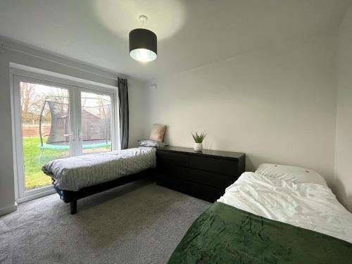 um quarto com 2 camas e uma janela em Cosy 4-Bed House in Manchester em Manchester