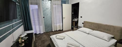 a small bedroom with a bed and a window at Casa Perla Nordului in Moisei
