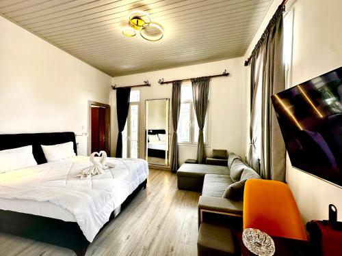 ein Schlafzimmer mit einem großen Bett und einem Sofa in der Unterkunft Travelers Luxury Suites, Studios & Apartments in Ágios Rókkos