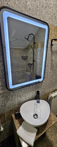 a mirror above a white sink in a bathroom at Casa Perla Nordului in Moisei