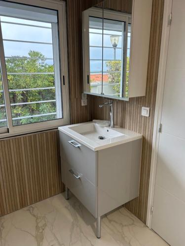 łazienka z umywalką, lustrem i oknem w obiekcie Villa magnifique vue mer w mieście Banyuls-sur-Mer