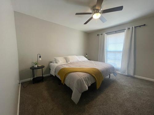 a bedroom with a bed with a ceiling fan at Cute & Cozy Suite in Overland Park in Overland Park