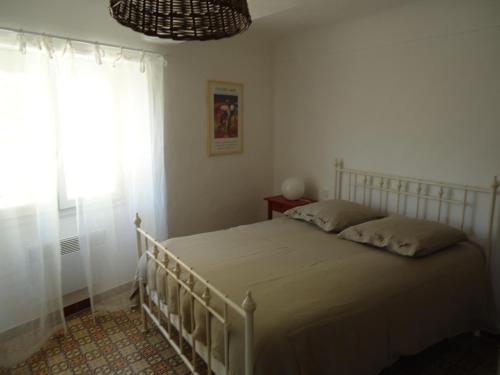 une chambre avec un lit blanc avec une fenêtre dans l'établissement LA MAISON D'AURELINE, à Châteauneuf-Val-Saint-Donat