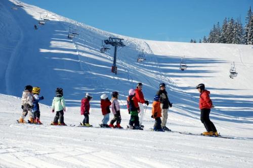 un grupo de niños esquiando en una pista de esquí en Relax Apartment, en Krumbach