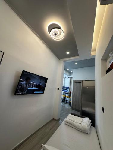 sala de estar con TV de pantalla plana en la pared en Travelers Luxury Suites, Studios & Apartments en Agios Rokkos