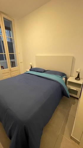 a blue bed in a room with a window at Buen sitio si tu plan es estar unos días en BCN in Barcelona