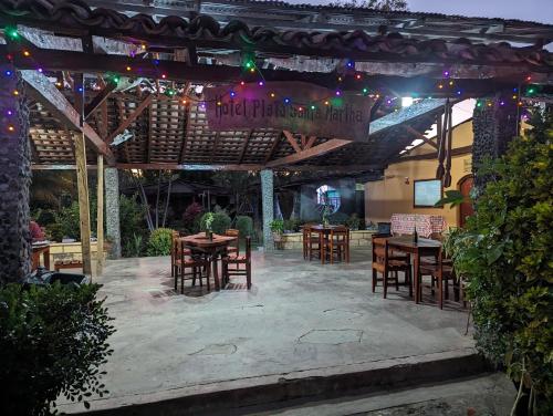 a patio with tables and chairs under a pergola at Hotel Playa Santa Martha in Rivas