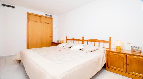 トレビエハにあるOrihuela 71のベッドルーム1室(白い大型ベッド1台、木製キャビネット付)