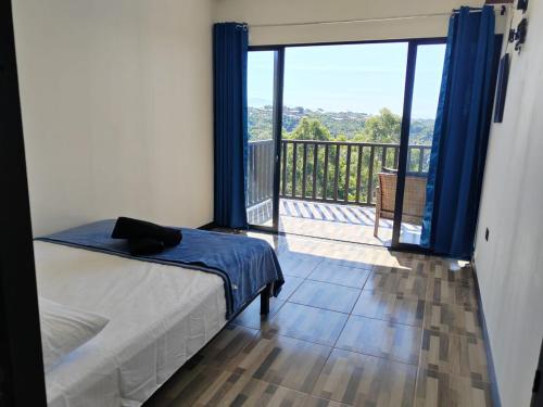 a bedroom with a bed and a balcony with a view at El Paraíso Escondido in San Juan