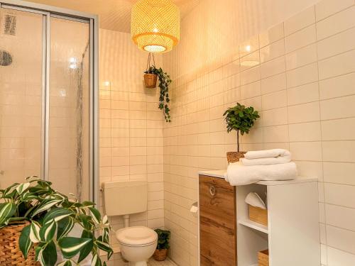 een badkamer met een toilet en een potplant bij Top Lage - Bali-Appartment Hamburg in Hamburg