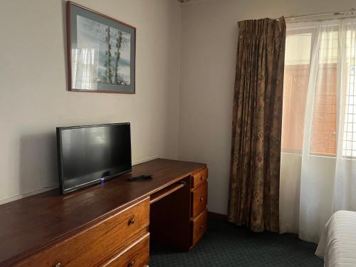 a tv on a dresser in a room with a bed at Soluxe el sesteo in San José