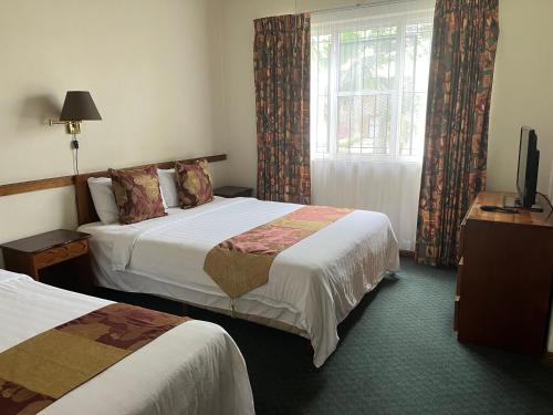 a hotel room with two beds and a window at Soluxe el sesteo in San José