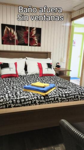 a bedroom with a bed with a black and white comforter at Hostal Host Patagonia in Punta Arenas