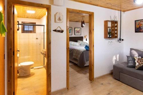 een kamer met een slaapkamer, een bed en een bank bij Cabana do Lago in Treze Tílias