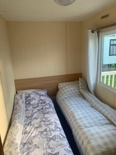 - une chambre avec 2 lits et une fenêtre dans l'établissement A14 is a 3 bedroom caravan on Whitehouse Leisure park with large decking, à Abergele
