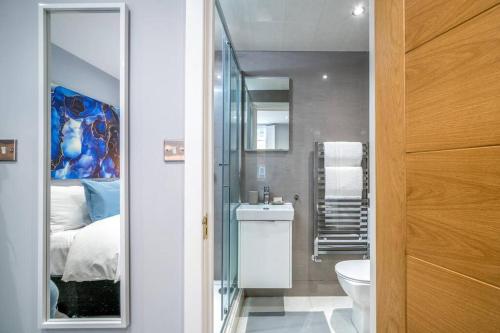 uma casa de banho com uma cama, um lavatório e um espelho. em Luxury 5 bedroom house in Star Street em Londres