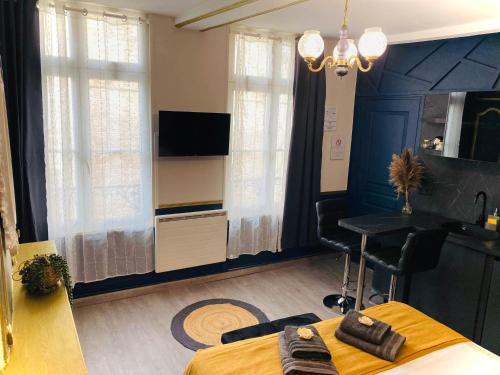 Schlafzimmer mit einem Bett, einem Schreibtisch und einem TV in der Unterkunft Studio Royal Saint-Omer Centre in Saint-Omer