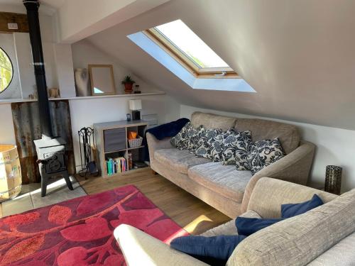a living room with two couches and a window at The Hayloft, Marsden in Huddersfield