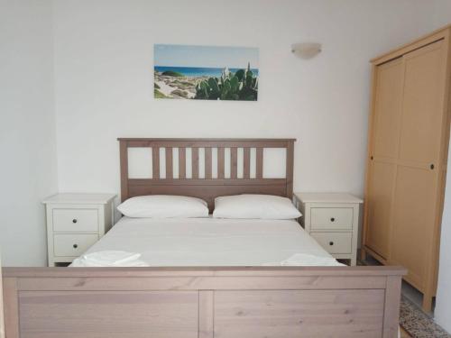 a bedroom with a wooden bed with two night stands at Salento Rooms in Leverano