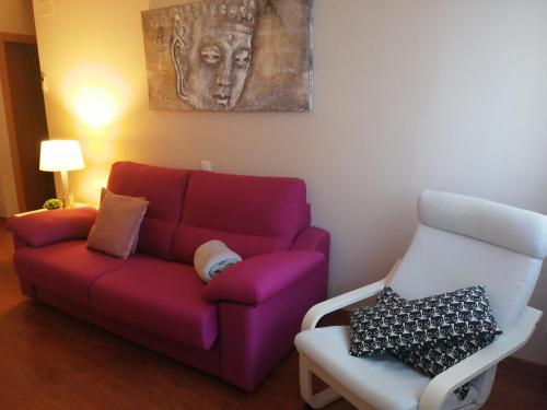 sala de estar con sofá púrpura y silla en CA LA VICKY en Deltebre