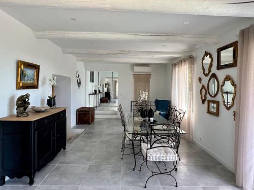 une salle à manger avec une table et des chaises en verre dans l'établissement La villa du soleil, à Nîmes