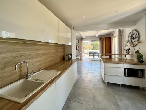 une cuisine avec un évier et un plan de travail dans l'établissement La villa du soleil, à Nîmes