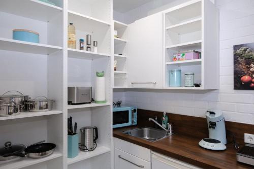 a white kitchen with a sink and a microwave at SchlossCasa Lauf an der Pegnitz (London) in Lauf an der Pegnitz