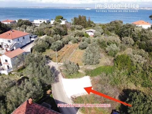 an aerial view of a house with a red arrow at jm-Sutomišćica-holiday house on the beach in Sutomišćica