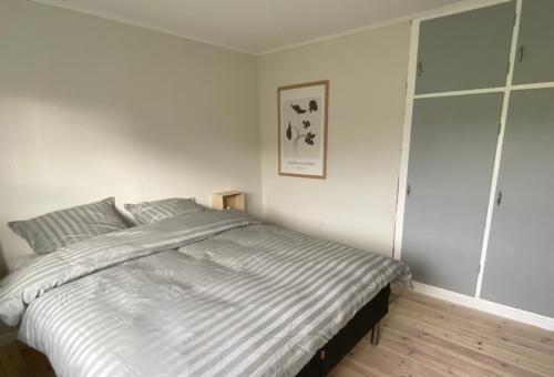 a bedroom with a large bed with striped sheets at STAY-Atlantic in Skálavík