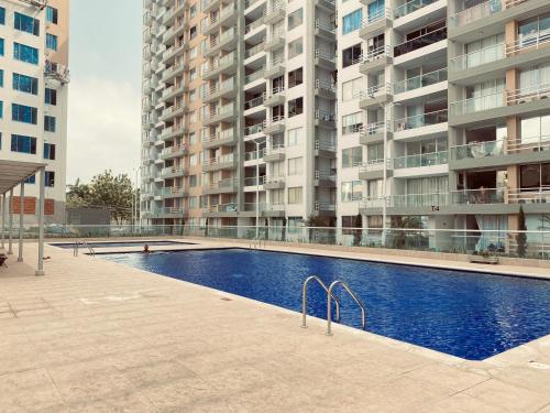 una piscina di fronte ad alcuni edifici alti di Apartamento céntrico Plazuela a Barranquilla
