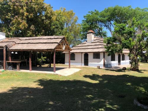 an old house with a thatched roof in a yard at Casa de campo Rincon in San José del Rincón