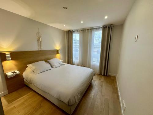 une chambre avec un grand lit et une grande fenêtre dans l'établissement TD HOUSE, à Paris