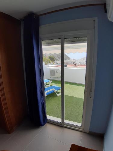 eine Glasschiebetür mit Blick auf einen Hof in der Unterkunft casa con cochera in Agua Amarga