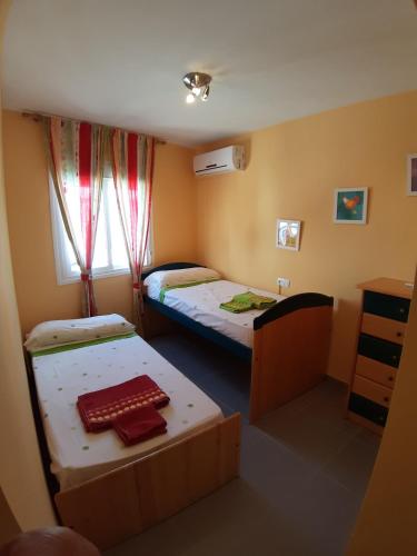 ein kleines Zimmer mit 2 Betten und einem Fenster in der Unterkunft casa con cochera in Agua Amarga