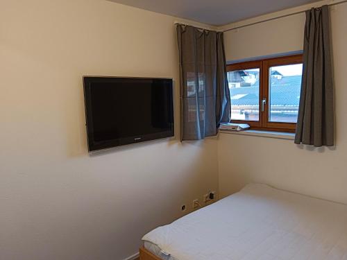 a bedroom with a flat screen tv on the wall at 1 Zimmer Appartement nahe Gmunden Top2 in Pinsdorf
