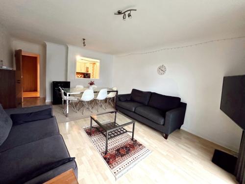 a living room with a couch and a table at Specious en-suite room - a cosy homestay close to Tower Bridge in London