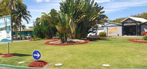 a golf course with a palm tree and a sign at Folle Anse Paradise in Saint-Louis