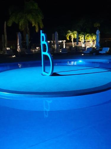 a blue sign in the middle of a pool at night at Folle Anse Paradise in Saint-Louis