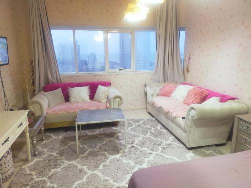Sala de estar con 2 sofás y mesa en OMAR HOSTEL FOR BOYS en Dubái