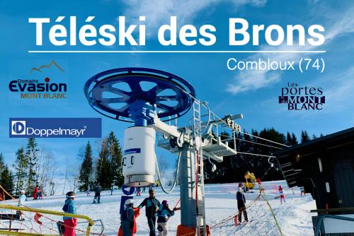 ein Poster für ein Skigebiet mit Menschen auf einem Skilift in der Unterkunft Vue Mont blanc, ski et village in Combloux