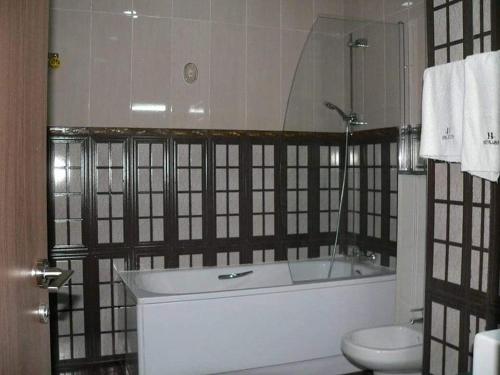 a bathroom with a bath tub and a toilet at Hôtel Lina in Bordj Bou Arreridj