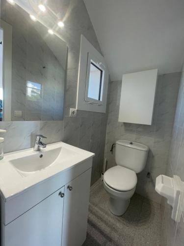 een witte badkamer met een toilet en een wastafel bij Platja La Fosca in Palamós